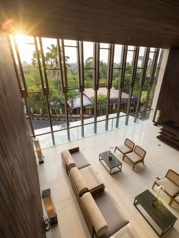 Helle Lobby mit hohen Fenstern und Blick auf tropische Vegetation