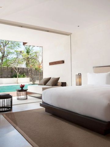 Zimmer mit weißem Bett und Terrasse mit privatem Pool und Liegen