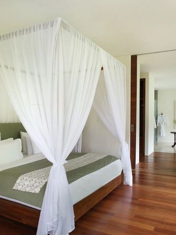 Helles Schlafzimmer mit edlem Holzboden, Baldachinbett und stilvollem Dekor