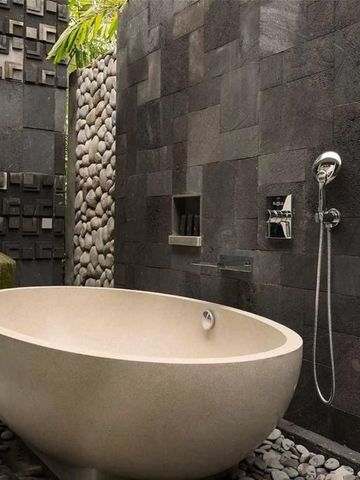 Freistehende Badewanne in stilvollem Steindesign im Alila Ubud.