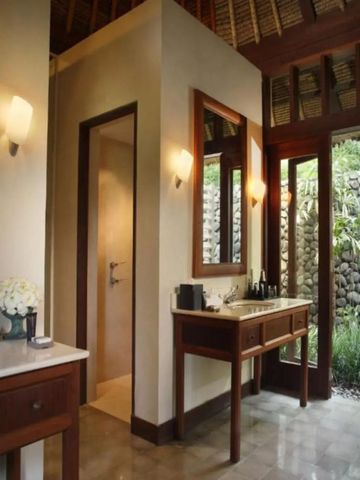 Elegantes Badezimmer mit hölzernem Interieur und Gartenausblick im Alila Ubud.