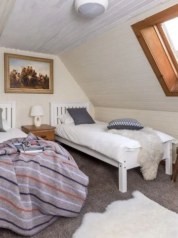 Gemütliches Dachzimmer mit Einzelbetten und einem Dachfenster