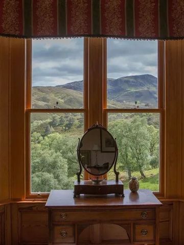 Großes Fenster mit Blick auf die schottische Landschaft und Schminktisch