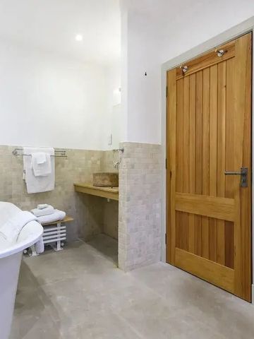 Modernes Badezimmer mit hölzerner Tür und freistehender Badewanne