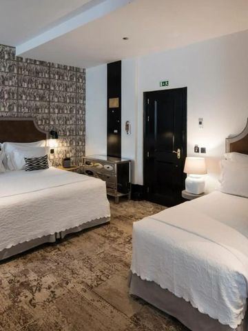 Hotelzimmer mit einem Doppelbett und einem Einzelbett in modernem Design.