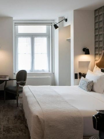 Helles Hotelzimmer mit großem Bett und Arbeitsbereich