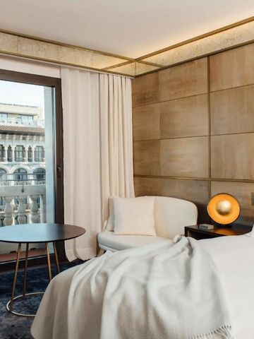 Helles Hotelzimmer mit Sitzbereich und Blick auf Barcelona