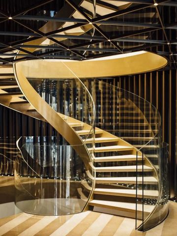 Elegante Wendeltreppe mit modernem Design und Glasgeländer in luxuriösem Ambiente