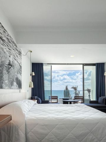 Helles Hotelzimmer mit Meerblick und moderner Einrichtung.