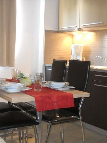 Essbereich in einer Suite mit gedecktem Tisch und moderner Küchenzeile