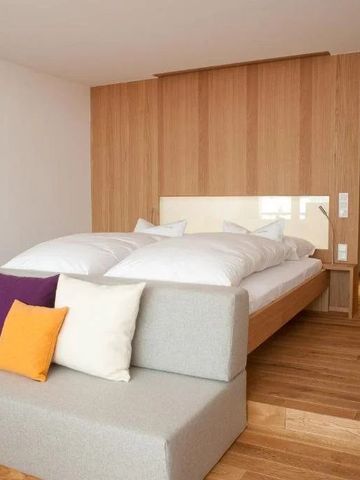 Helles Zimmer mit Holzdekor und bequemen Sitzmöbeln