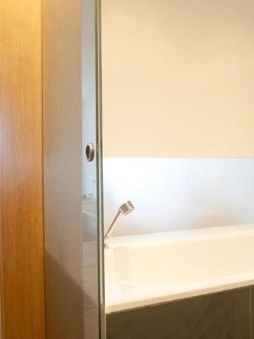 Geräumiges Badezimmer mit Badewanne und sanftem Licht