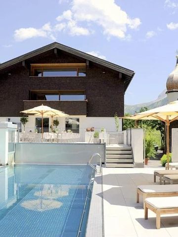 Hotelpool mit Sonnenliegen und Bergblick