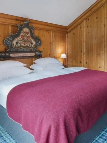 Traditionelles Hotelzimmer mit Holzelementen und farbiger Decke