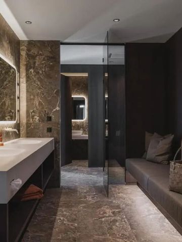 Luxuriöses Badezimmer mit marmorierten Wänden und großem Spiegel