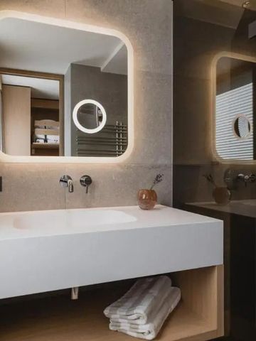 Modernes Badezimmer mit beleuchtetem Spiegel und offener Ablage