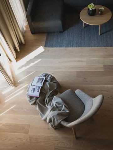 Luftige Lounge mit Sessel Tisch und Zeitschrift aus der Vogelperspektive