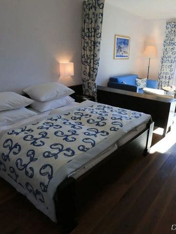 Modernes Hotelzimmer mit großer Fensterfront und Sitzbereich