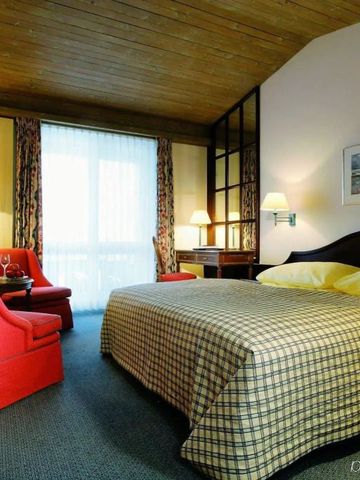 Hotelzimmer mit traditionellem Charme und gemütlichen Sitzmöbeln