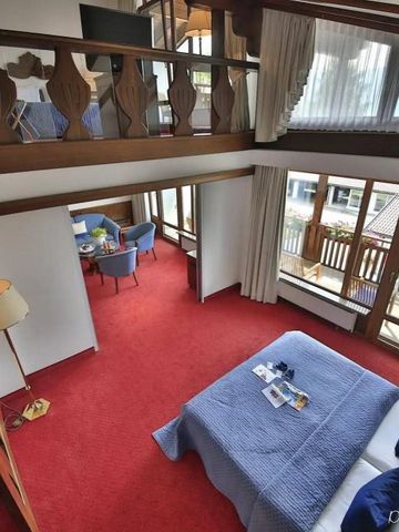 Galeriezimmer mit rotem Teppich und gemütlicher Sitzecke