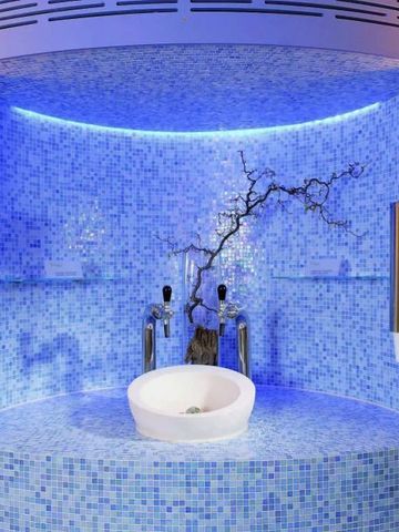 Moderne Waschstation mit blauem Mosaik und stilvoller Beleuchtung