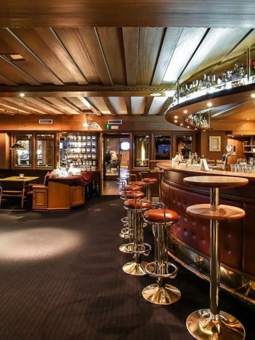 Gemütliche Hotelbar mit Holzdekor und luxuriösen Ledersesseln
