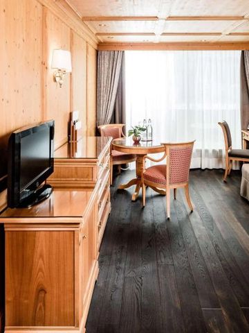 Helles Hotelzimmer mit Holzmöbeln und großen Fenstern