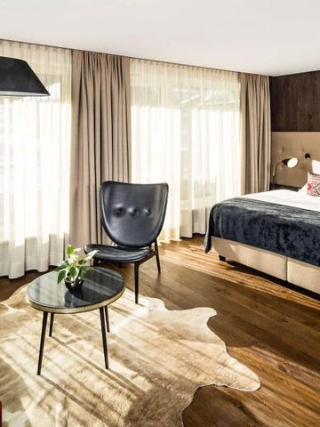 Modernes und stilvolles Hotelzimmer mit großem Bett und Designerstuhl