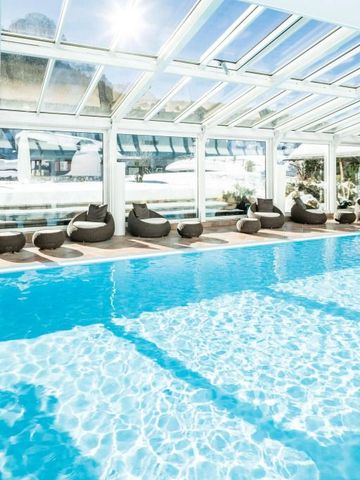 Innenpool mit Glasdach und bequemen Liegen im Alpenroyal Hotel