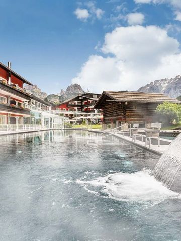 Beheizter Außenpool mit Wasserfall und Bergblick im Alpenroyal Hotel