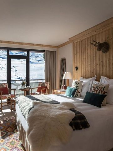 Komfortables Zimmer mit großem Fenster und atemberaubendem Alpenblick, rustikal dekoriert.