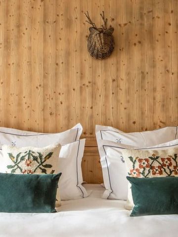 Gemütliches Schlafzimmer mit Holzwand und dekorativen Kissen