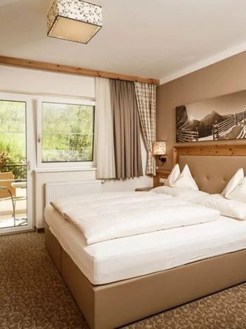 Rustikales Zimmer mit gemütlichem Doppelbett und Balkon.