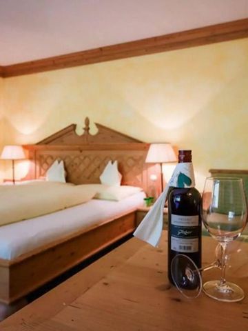 Gemütliches Hotelzimmer mit Holzmöbeln und Weinflasche auf dem Tisch