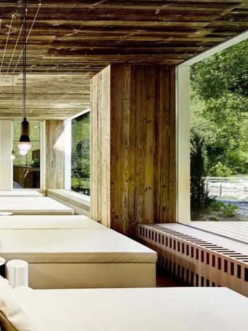 Entspannungsbereich mit Holzdecke und Panoramablick ins Grüne