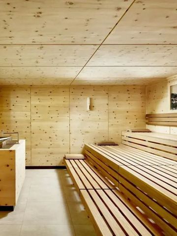 Saunaraum aus Holz mit Liegebänken und beruhigender Atmosphäre.