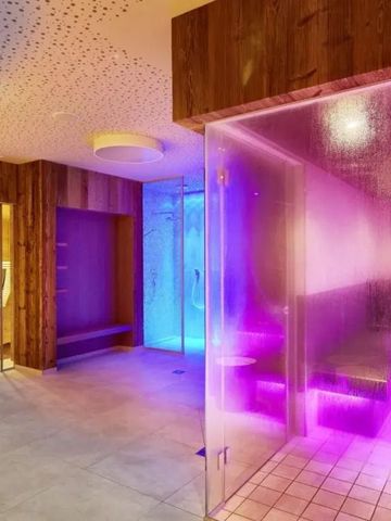 Moderner Wellnessbereich mit Dampfbad und Regenwalddusche in bunten Farben.