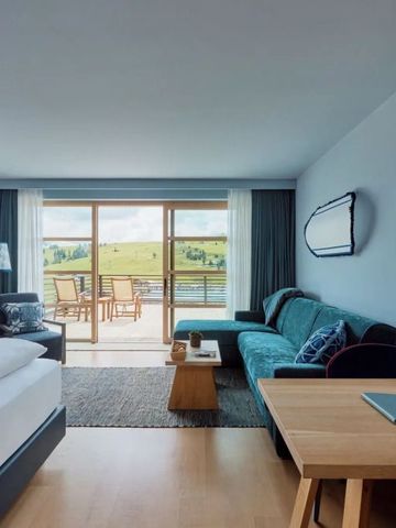 Helles Hotelzimmer mit Blick auf Balkon und grüne Landschaft