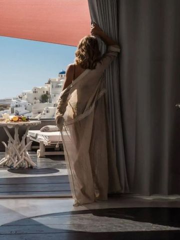 Frau blickt von einer Suite auf eine Sonnenterrasse mit Panoramablick.