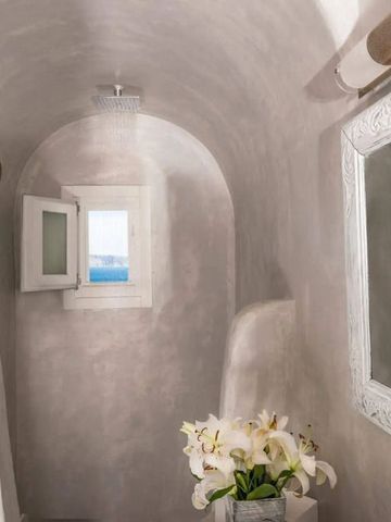 Luxuriöses Badezimmer mit Meerblick und dekorativem Spiegel.