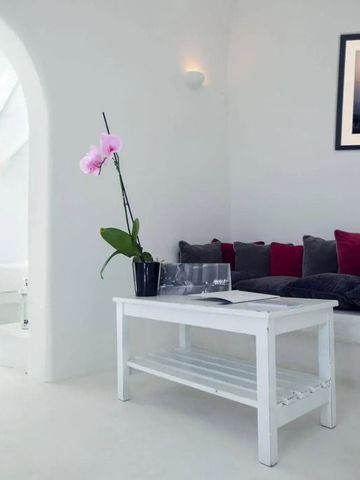 Helles Hotelzimmer mit weißer Einrichtung und Farbakzenten in Rot.