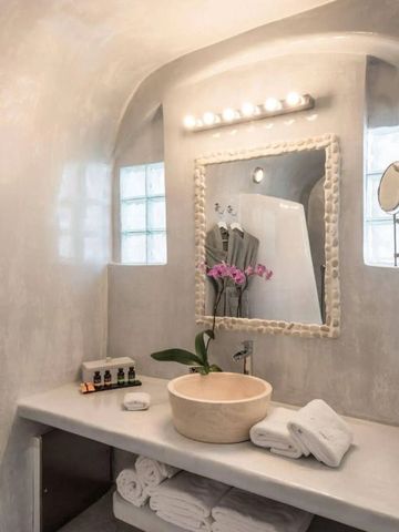 Luxuriöses Badezimmer mit Rundspiegel und eleganter Beleuchtung.