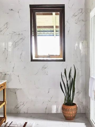 Modernes Badezimmer mit Marmordetails und großen Fenstern