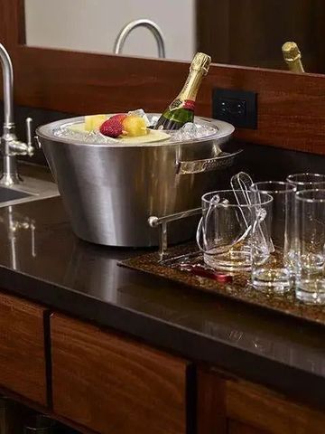 Minibar mit Champagner und Gläsern auf edler Anrichte