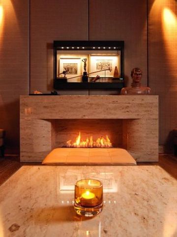 Gemütlicher Raum mit Kamin und Kerze auf Tisch