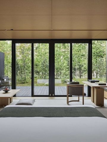 Geräumiges Zimmer mit großen Fenstern und Waldpanorama