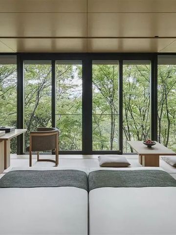 Helles Zimmer mit Panoramafenstern und Blick auf üppige Bäume