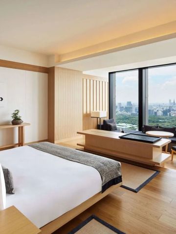 Helles Zimmer mit großen Fenstern und Sicht auf Tokio im Aman Tokyo