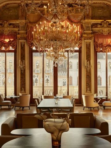 Prunkvoller Speisesaal mit Kronleuchtern und Blick auf Venedig.