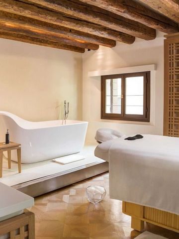 Luxus-Spa-Bereich mit freistehender Badewanne und Holzbalken.